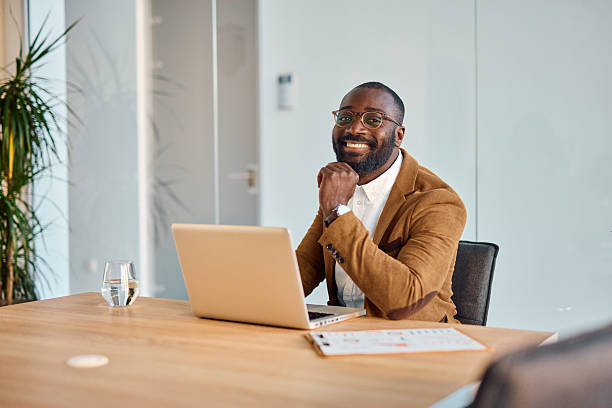 istock Smiling businessman working with laptop at office desk 2214939124