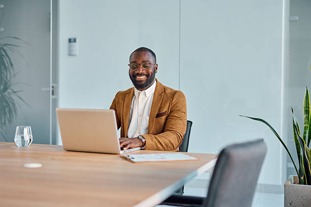 istock Smiling businessman working on laptop in modern office 2214939125