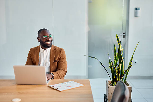 istock Smiling businessman working on laptop in modern office 2214939135