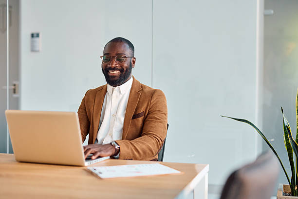 istock Smiling businessman working on laptop in modern office 2214939241