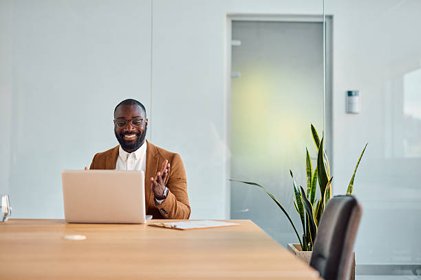 istock Smiling businessman having video call on laptop in modern office 2214939314