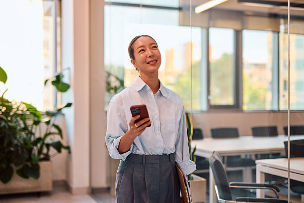 istock Professional Woman Engaging with Smartphone in Office 2214939315