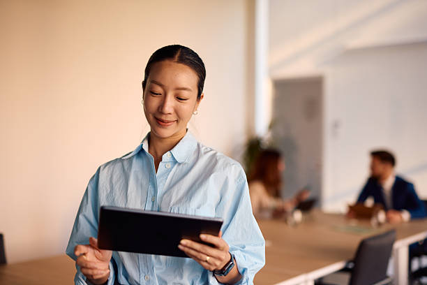 istock Young Asian businesswoman using digital tablet in modern office 2214939353