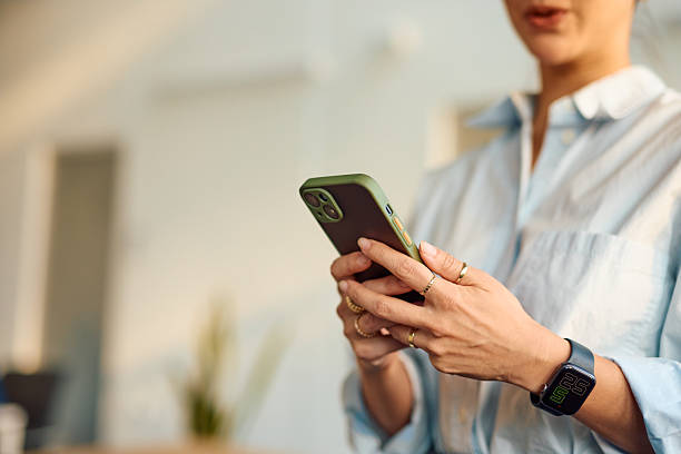 istock Businesswoman using smartphone, typing a message and wearing a smartwatch 2214939713