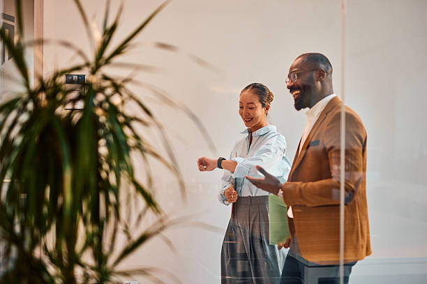 istock Businesspeople checking time walking in office corridor during break time 2214939724