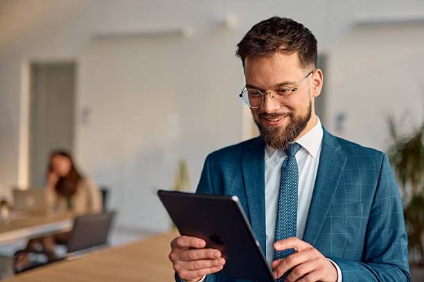 istock Businessman smiling and using digital tablet in modern office 2214939972