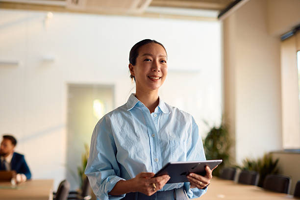 istock Smiling businesswoman holding tablet in modern office 2214941012