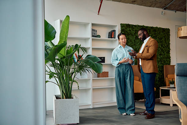 istock Business people using mobile phone and discussing work in modern office 2214941322