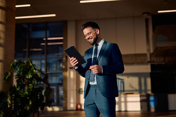 istock Smiling businessman using digital tablet in modern office 2214941352