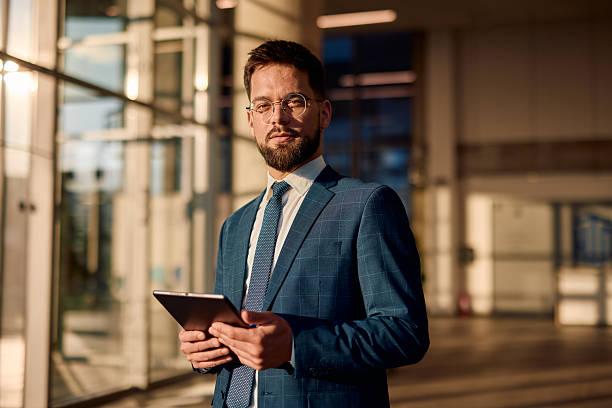 istock Confident businessman holding tablet in modern office building 2214941406