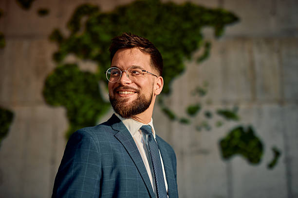 Smiling businessman looking away with world map in background