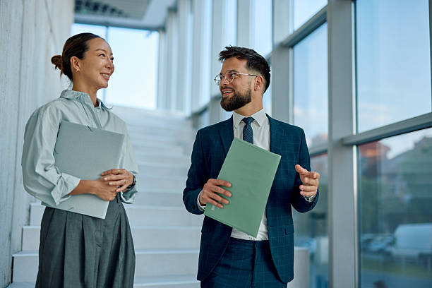 istock Business partners walking and talking in modern office building 2214941569