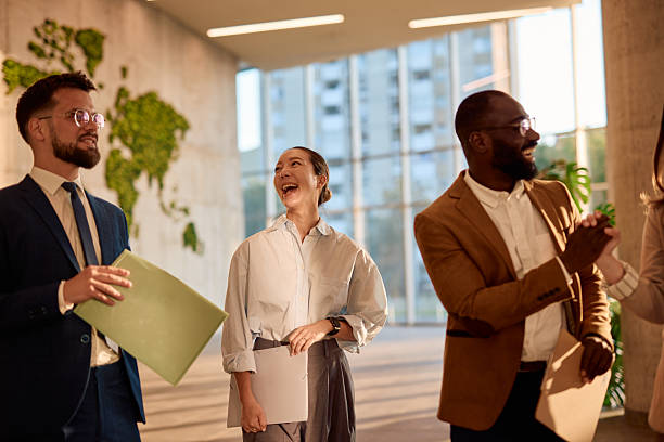 istock Businesspeople walking and talking in modern office lobby 2214941653