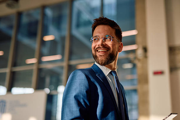 istock Smiling businessman looking away in modern office building 2214941717