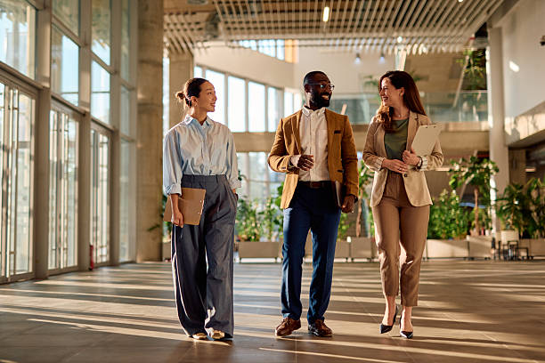 istock Businesspeople walking and talking in modern office building lobby 2214941820