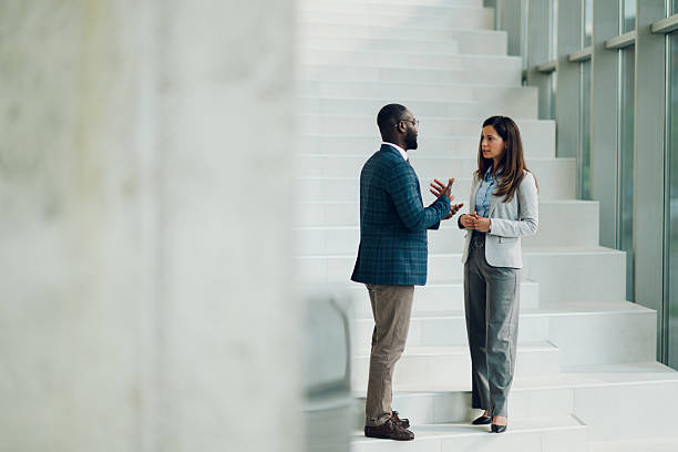 istock Businesspeople discussing work on modern office stairs 2214945746