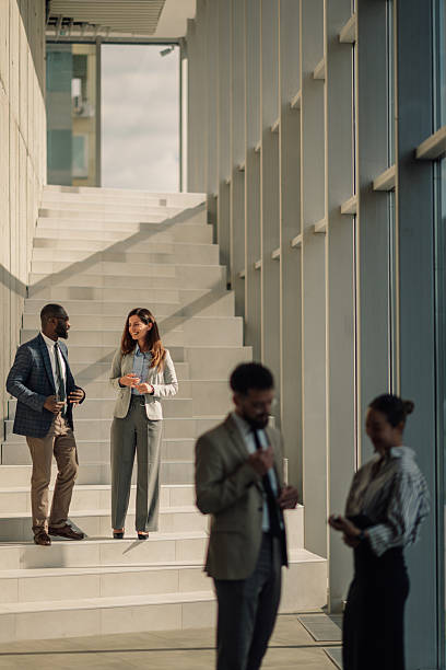 istock Business people talking on stairs in modern office building 2214945747