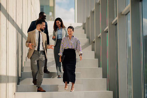 istock Businesspeople walking down stairs in modern office building 2214945772