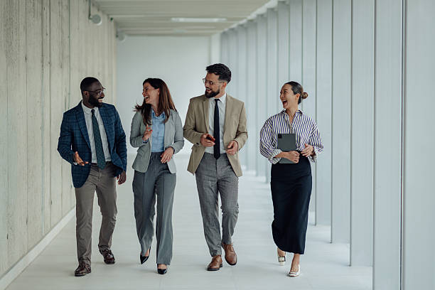 istock Happy multi-ethnic businesspeople walking and talking in office hallway 2214945804