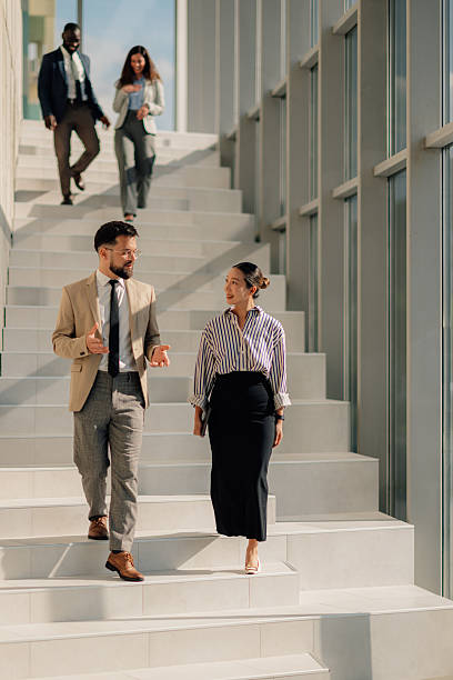 istock Business people walking and talking on stairs in modern office building 2214945829