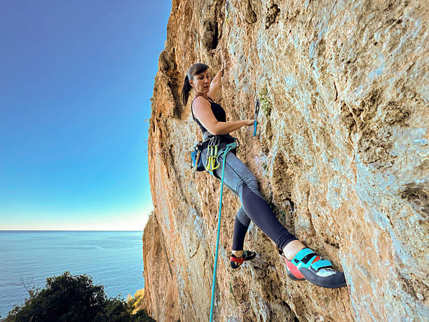 istock CLOSE UP, PORTRAIT: Woman climbs an exposed limestone wall above Mediterranean 2214946009