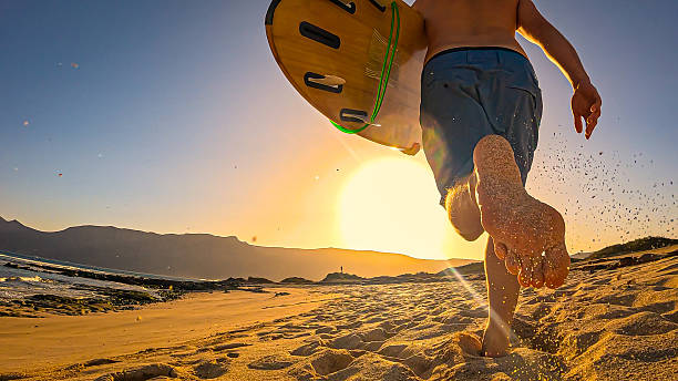 Surf skater training surfing moves near the beach at sunset.