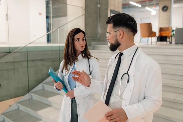 istock Doctors discussing patient information while walking in hospital corridor 2214947478
