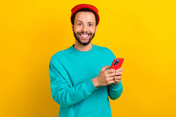 istock Portrait of impressed funky man dressed turquoise pullover hold smartphone impressed fast internet isolated on yellow color background 2214949930