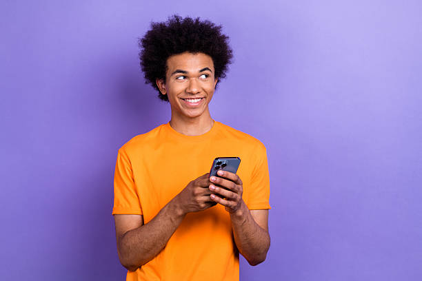 istock Photo of handsome creative man hod smart phone look empty space brainstorming isolated on violet color background 2214950321