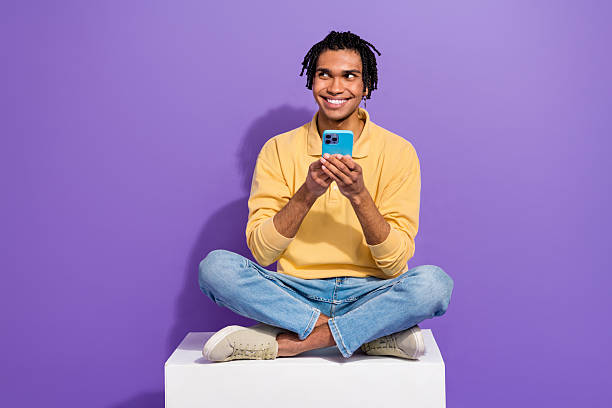 istock Full size photo of young man efficiency apple phone sit platform look novelty notification bank acc isolated on violet color background 2214953869