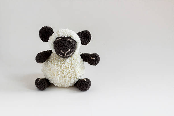 The Sacrifice Festival,Kurban Bayrami in TR,Concept with handmade little crocheted black and white color sheep sitting on the white background with copy space
