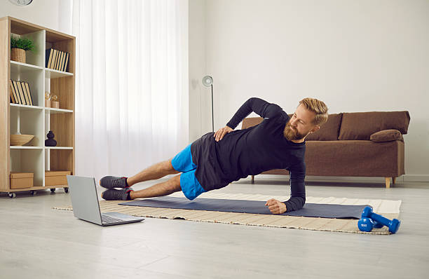 istock Fit man train at home with online lesson on computer 2214963980