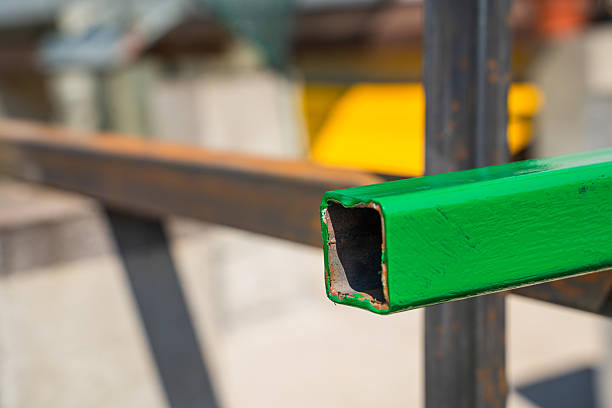 istock Square iron pipes freshly painted with green paint on a sunny day 2214975932