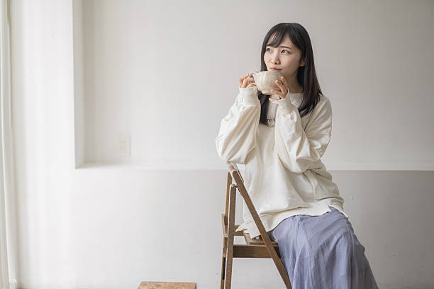 istock A woman relaxing in her room drinking coffee 2214980444