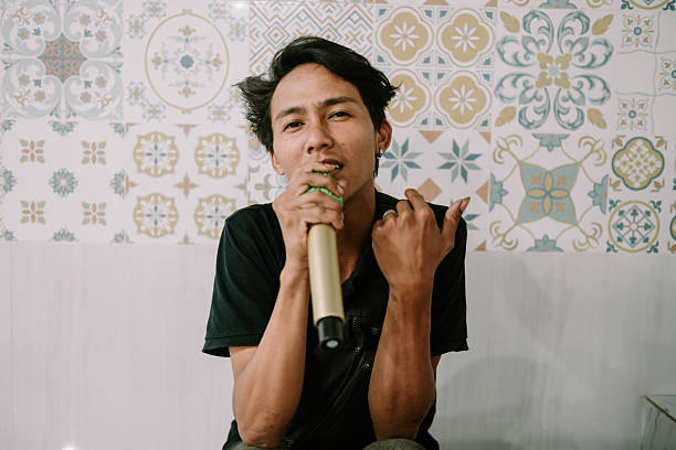 istock Passionate Asian Singer Performing with Microphone against Tile Background 2214981841