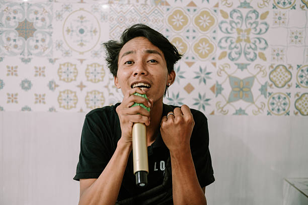 istock Passionate young asian man singing karaoke with enthusiasm and expression 2214981890