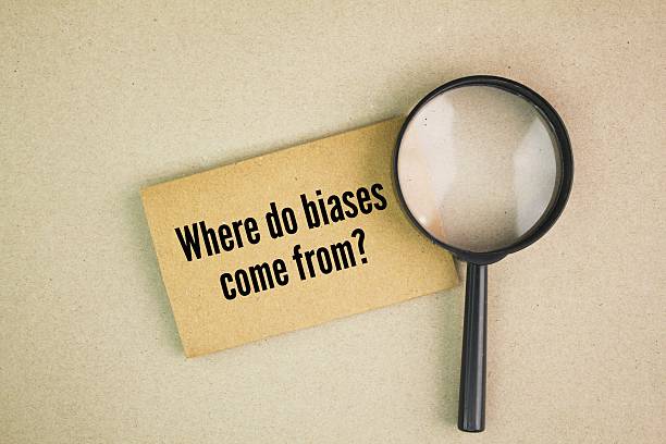 istock magnifying glass and paper with the question words Where do biases come from? 2214982247