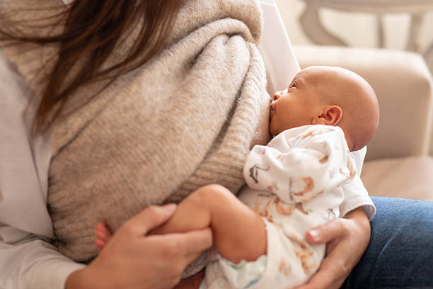 Young Latin American mother breastfeeding her newborn baby daughter at home - Buenos Aires - Argentina