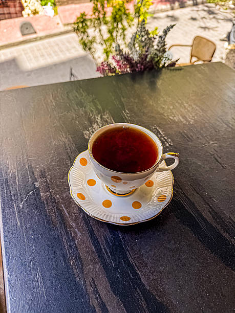 Elegant tea cup with saucer on dark surface, showcasing rich beverage and inviting ambiance