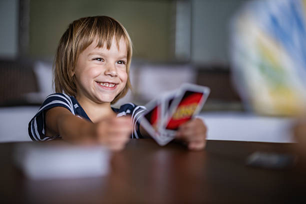 Happy boy having fun while playing cards at home. Copy space.