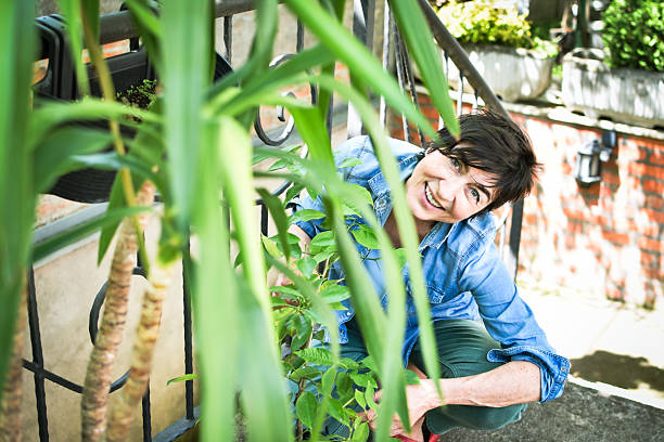 istock a middle-aged woman enjoys her plants 2214988651