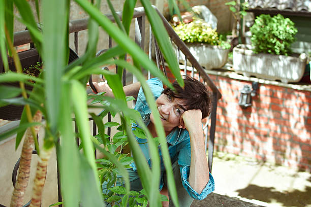 istock a middle-aged woman enjoys her plants 2214988661