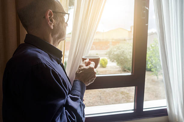 istock Senior Man Drinking Coffee near Window in Daylight 2214989358