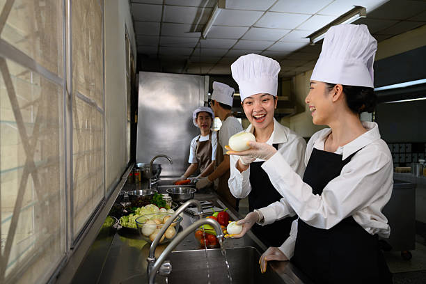 istock Smiling young chefs learning kitchen hygiene and teamwork in a professional cooking school 2214989564