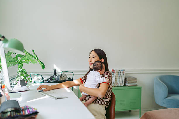 istock Mom working from home with a baby in her arms 2214989782
