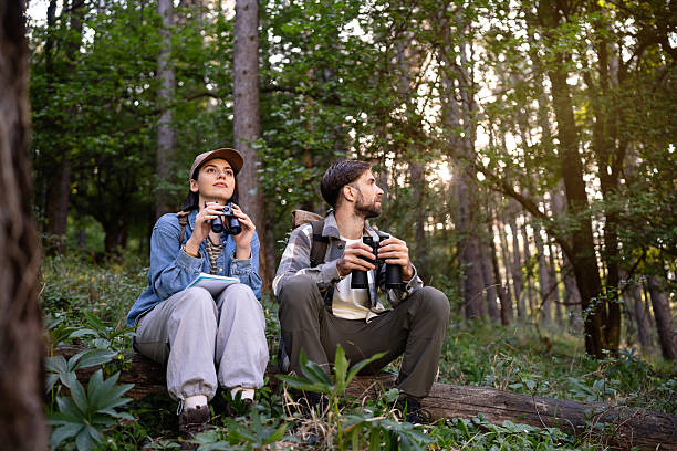 istock Young couple birdwatching in a lush forest setting during daytime 2214990889