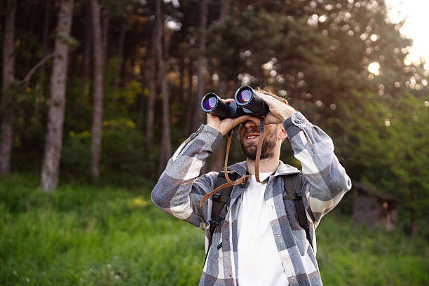 istock Man observing birds in nature with binoculars in a forested environment 2214991220