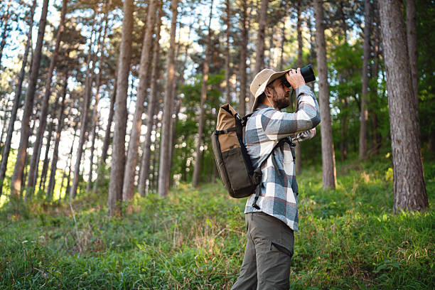 istock A man with binoculars birdwatching along a forested hiking trail 2214991389