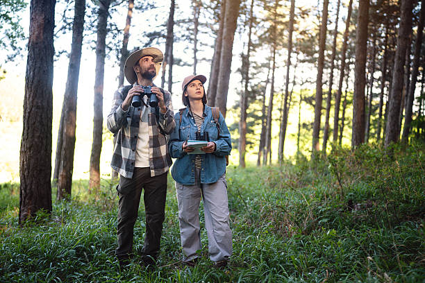 istock Two young people birdwatching in a serene forest environment 2214991647