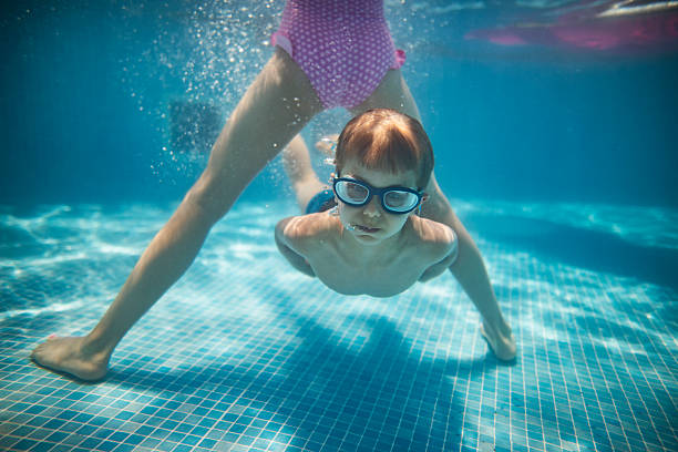 A young swimmer moves skillfully through the water, diving beneath the surface and weaving under each other.\nShot with D800